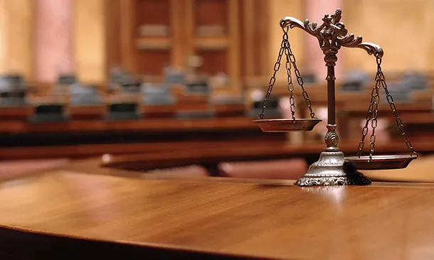 Balance de la justice dans une salle d'audience, symbolisant la représentation juridique et la défense des entreprises par la CVCI.